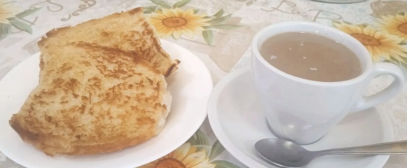 Sanduíche tostado com bebida quente na xícara