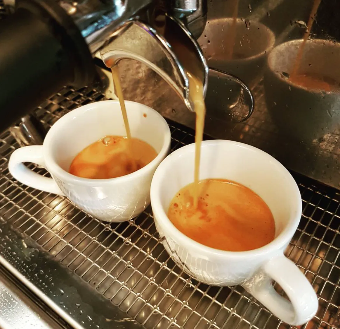 Café expresso sendo extraído em duas xícaras