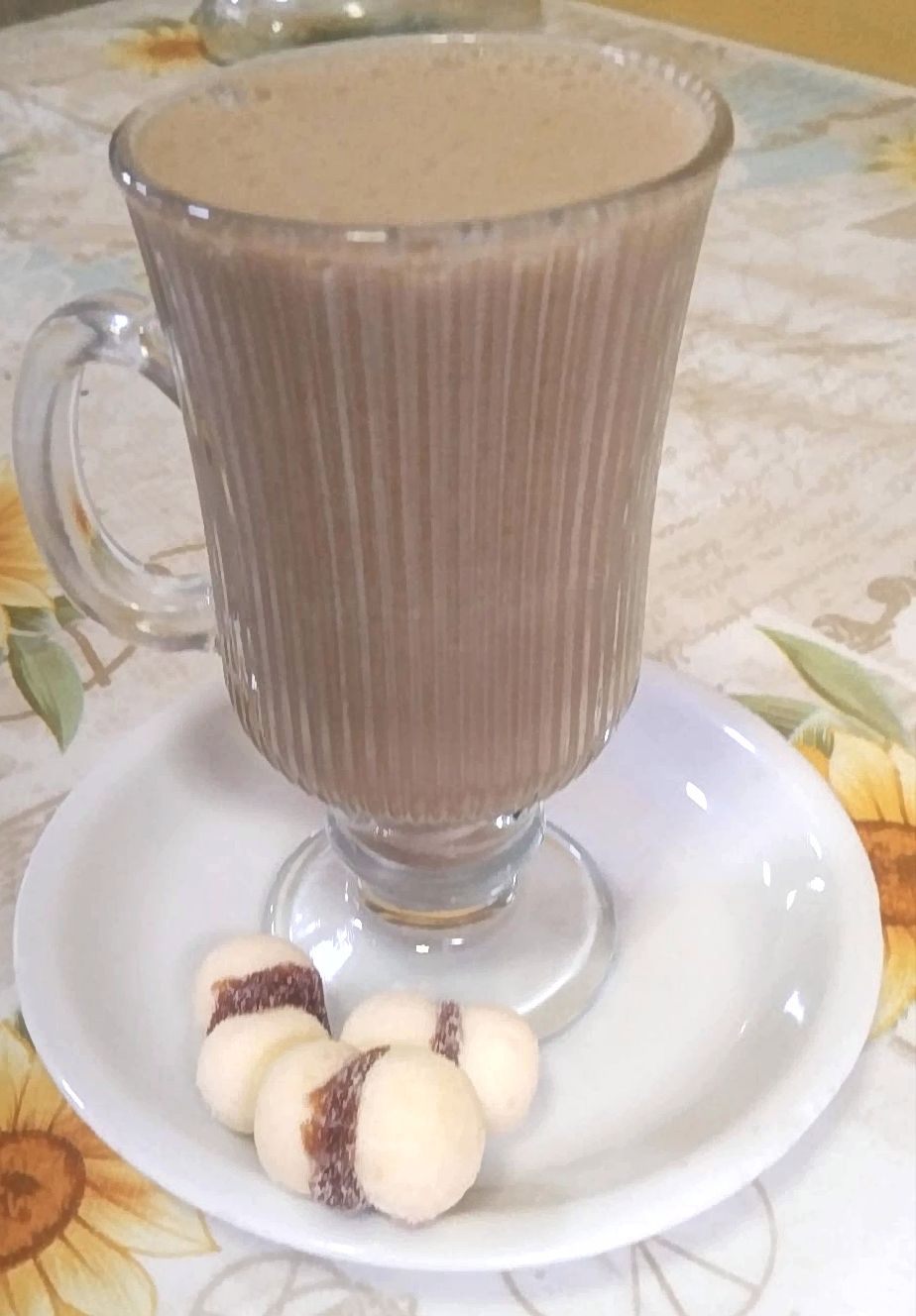 Capuccino servido em copo alto com biscoitos